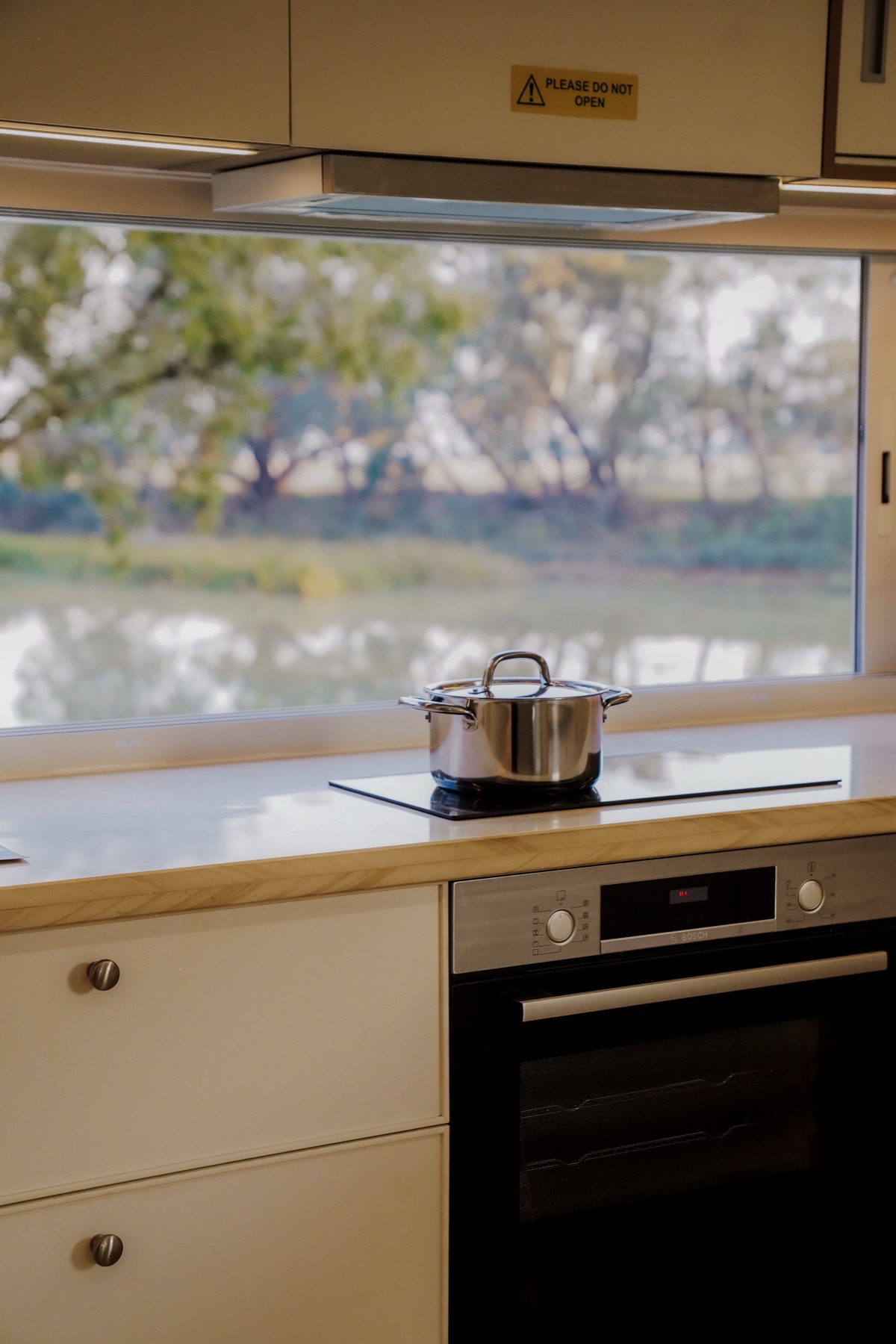 A pot on the stovetop inside the Bonsai one-bedroom kitchen.