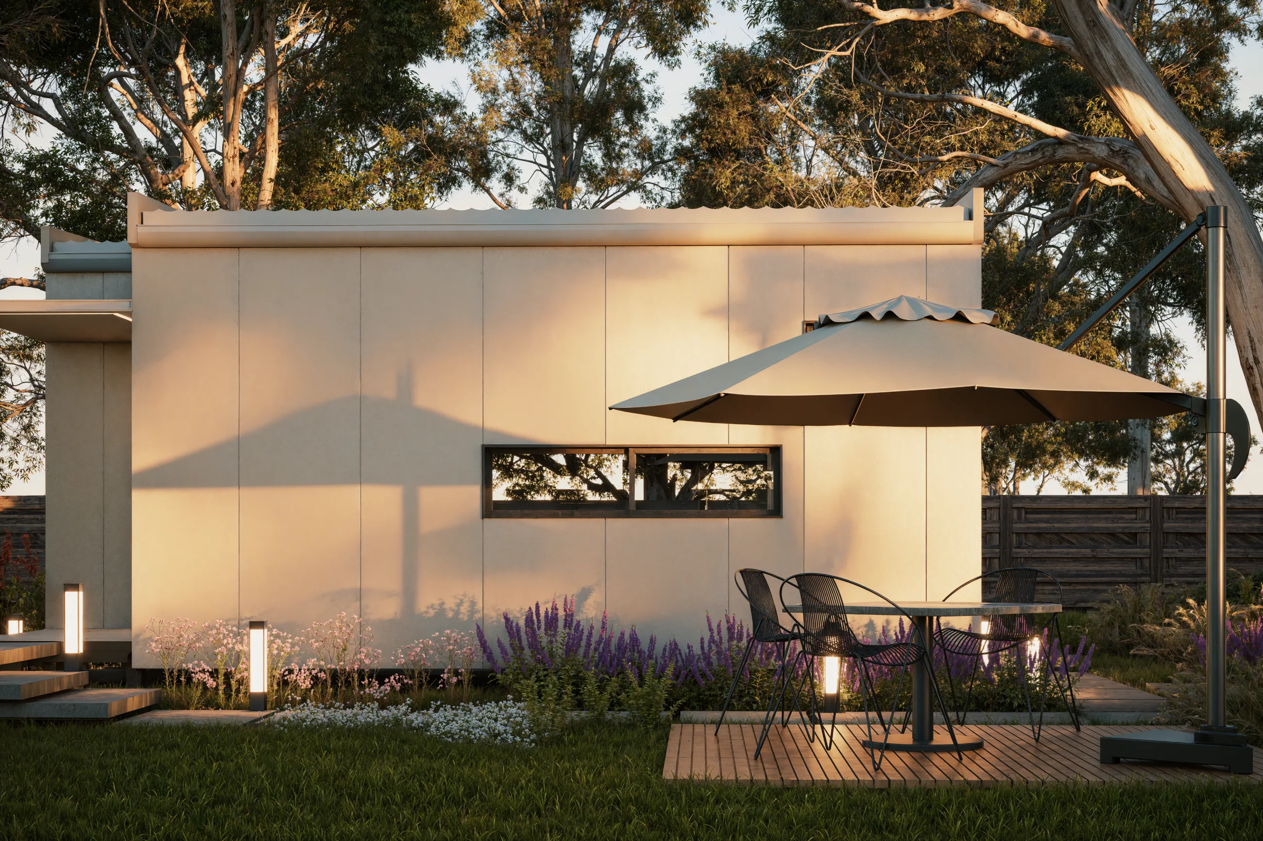 The Studio from the garden, with a deck, an umbrella and lavender beds